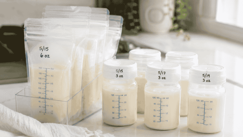 Breast milk storage bags and BPA-free bottles lined up on a clean kitchen counter