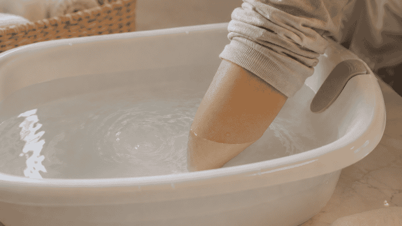 A parent carefully washing a newborn baby's face with a soft warm washcloth during a sponge bath