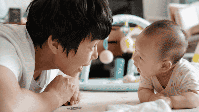 A parent and baby engaged in face-to-face back-and-forth vocalization and serve-and-return interaction to build language skills