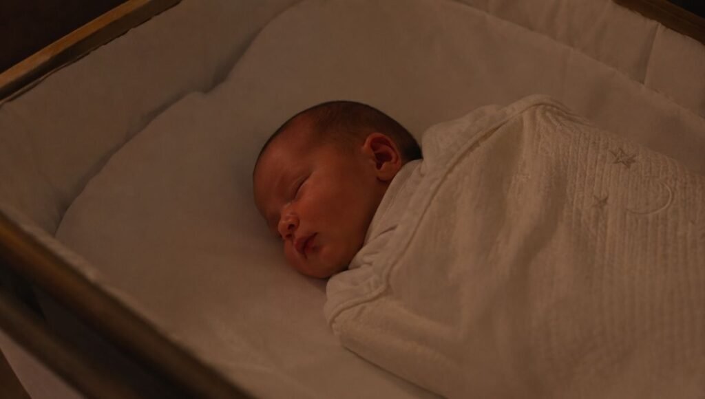 A newborn baby sleeping in short stretches in a white bassinet during the night, showing typical newborn sleep patterns